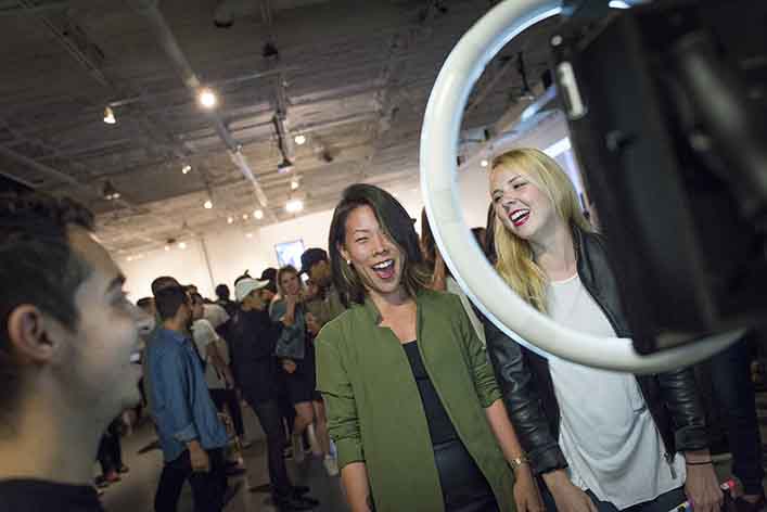 A woman takes a selfie at a photo booth. Infusing authenticity into your marketing helps form connections with audiences.